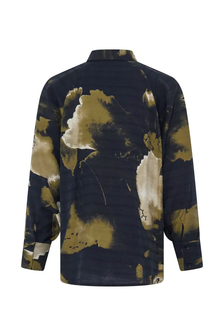 A long-sleeve button-up shirt shown from the back, featuring a dark navy blue base with an abstract watercolor-style print in olive green and cream.