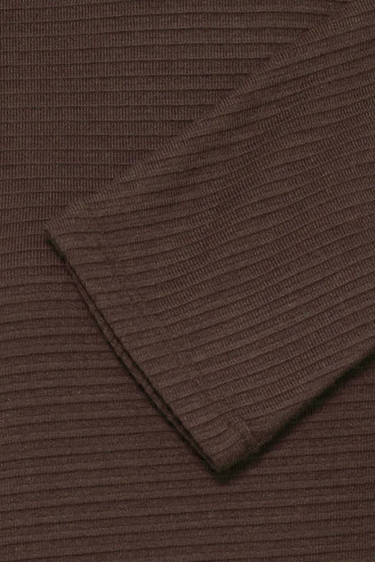 Close-up of a dark brown ribbed knit fabric, showing the texture and folded cuff detail.
