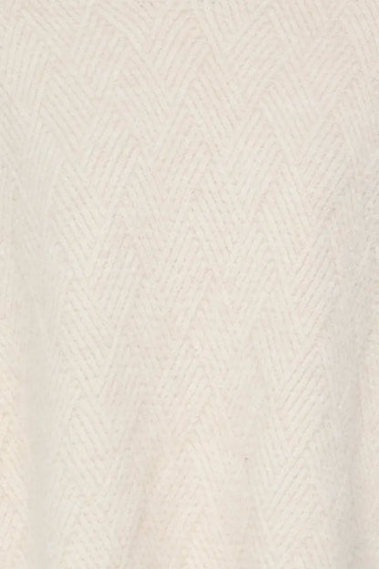 Close-up of a cream-colored knit fabric with a subtle herringbone pattern.