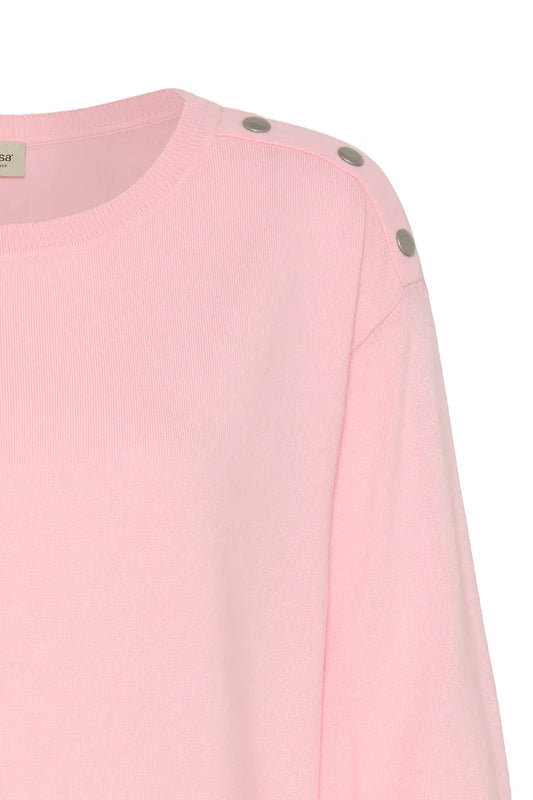 Close-up of a light pink knit top with three metallic silver buttons on the shoulder, shown against a plain white background.