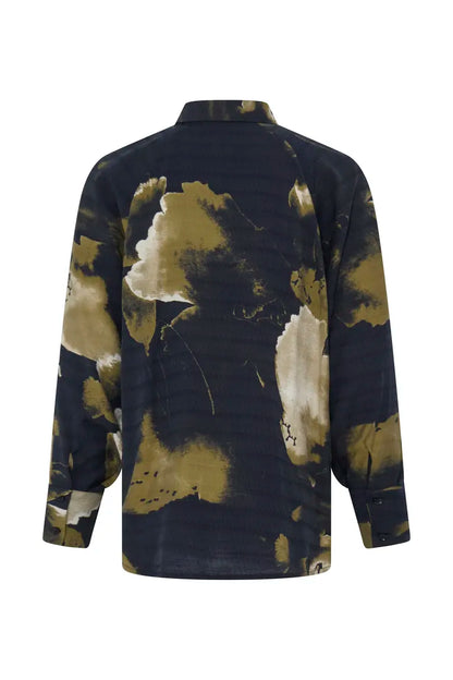 A long-sleeve button-up shirt shown from the back, featuring a dark navy blue base with an abstract watercolor-style print in olive green and cream.